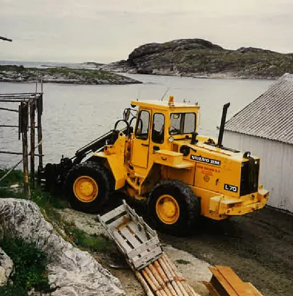 Gul Volvo hjullaster ved sjøen